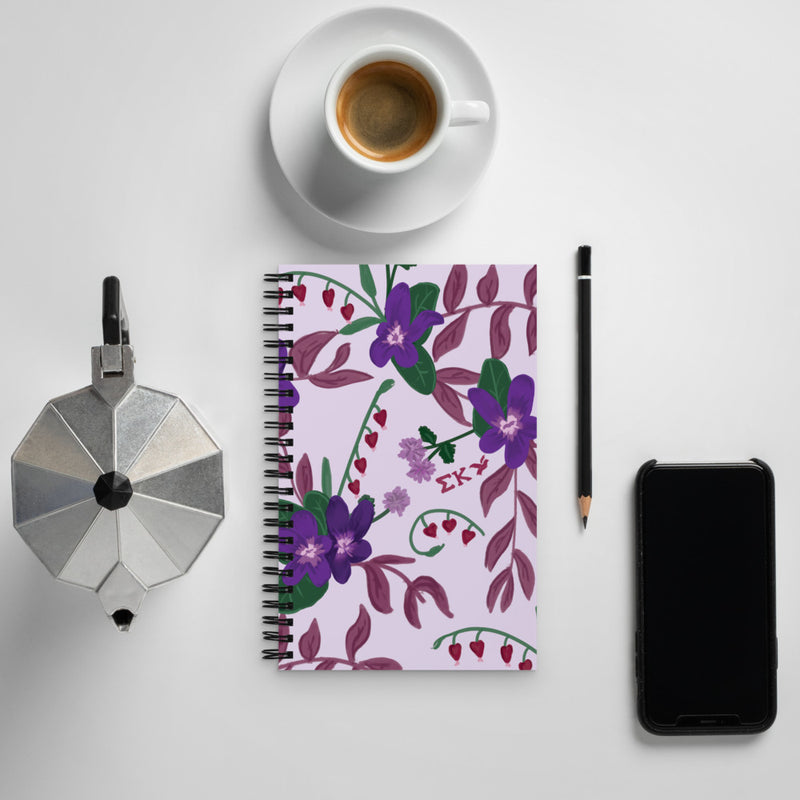 Sigma Kappa Violet Floral Print Spiral Notebook showing front cover in lifestyle setting