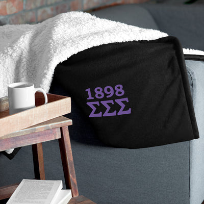 Tri Sigma 1898 Plush Sherpa Blanket in black on couch