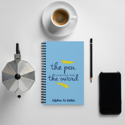 Alpha Xi Delta Pen Is Mightier Spiral Notebook shown with coffee