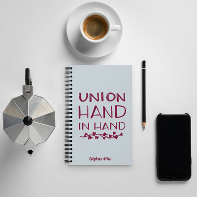 Take notes in style with our silver Alpha Phi Union Hand in Hand spiral notebook in Silver and Bordeaux. 