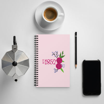Phi Mu 1852 Founding Date Pink Spiral Notebook shown with coffee