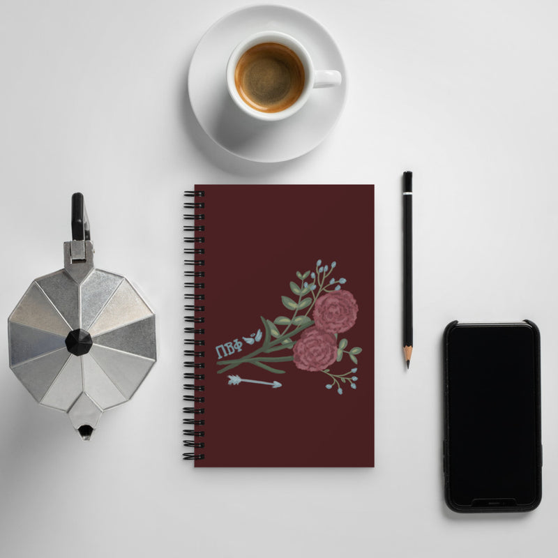Pi Beta Phi Carnation and Arrow Spiral Notebook shown with coffee