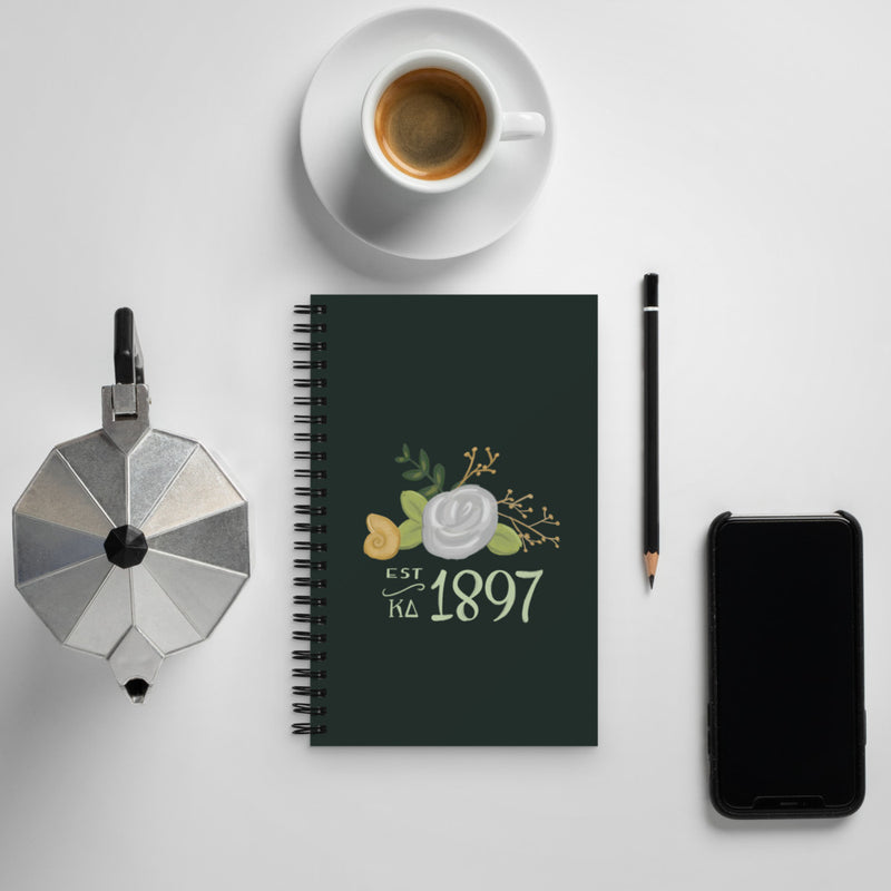 Kappa Delta 1897 Founding Year Spiral Notebook shown with coffee