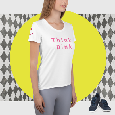 Think Dink Women's Pickleball T-Shirt in white with pink lettering on model in side view showing smile on sleeve