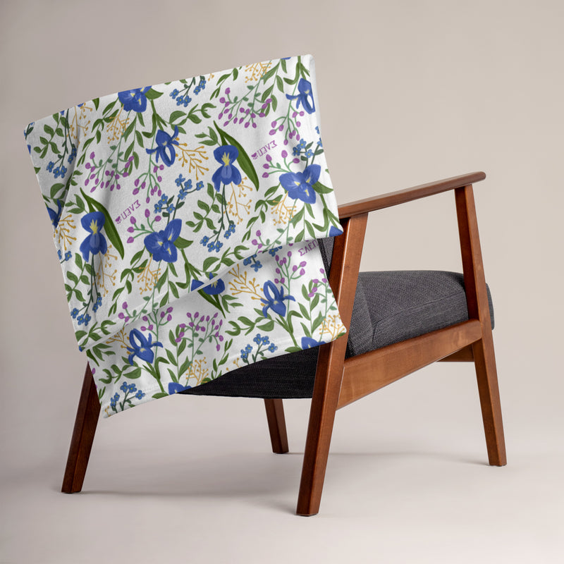 Sigma Alpha Epsilon Pi Floral Print Throw Blanket, White on chair