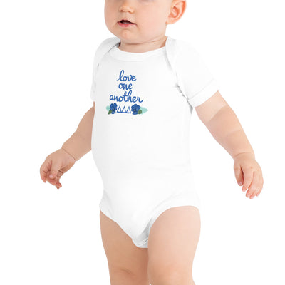Tri Delta Love One Another Baby Onesie in white shown on toddler model