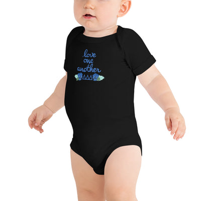 Tri Delta Love One Another Baby Onesie in black shown on toddler model