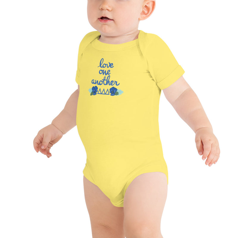 Tri Delta Love One Another Baby Onesie in yellow shown on toddler model