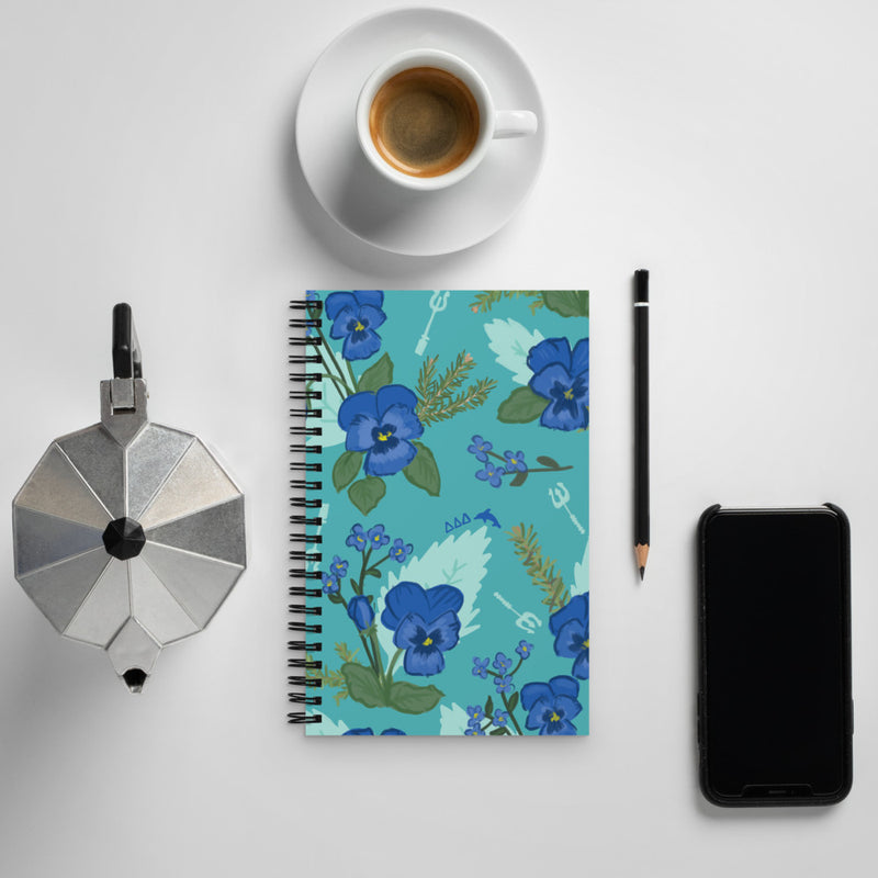 Tri Delta Sorority Notebook shown with pansy floral print in lifestyle setting