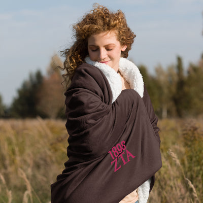 Zeta Tau Alpha 1898 Sherpa Blanket in brown shown with model